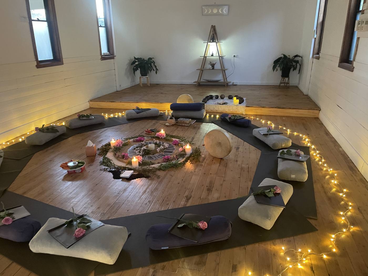 A women's circle room set with cushions, candles and roses